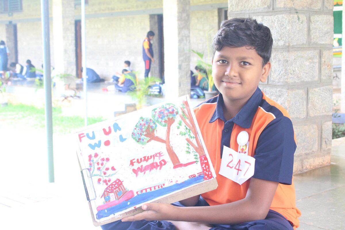 A student displaying his completed artwork with his participant number