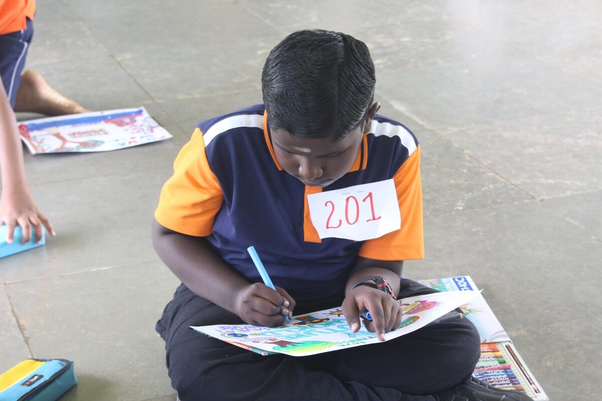 A student focused on his drawing during an art competition