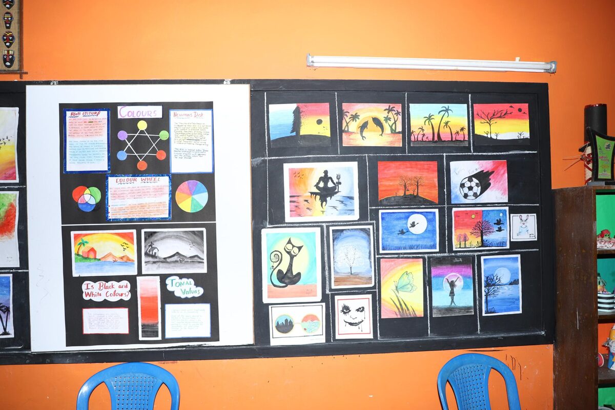 A bulletin board displaying colourful student artwork and a hand-painted colour wheel