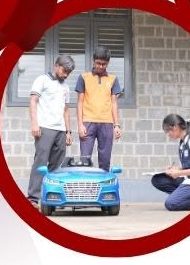 Students reviewing a scale prototype model of the autopilot car
