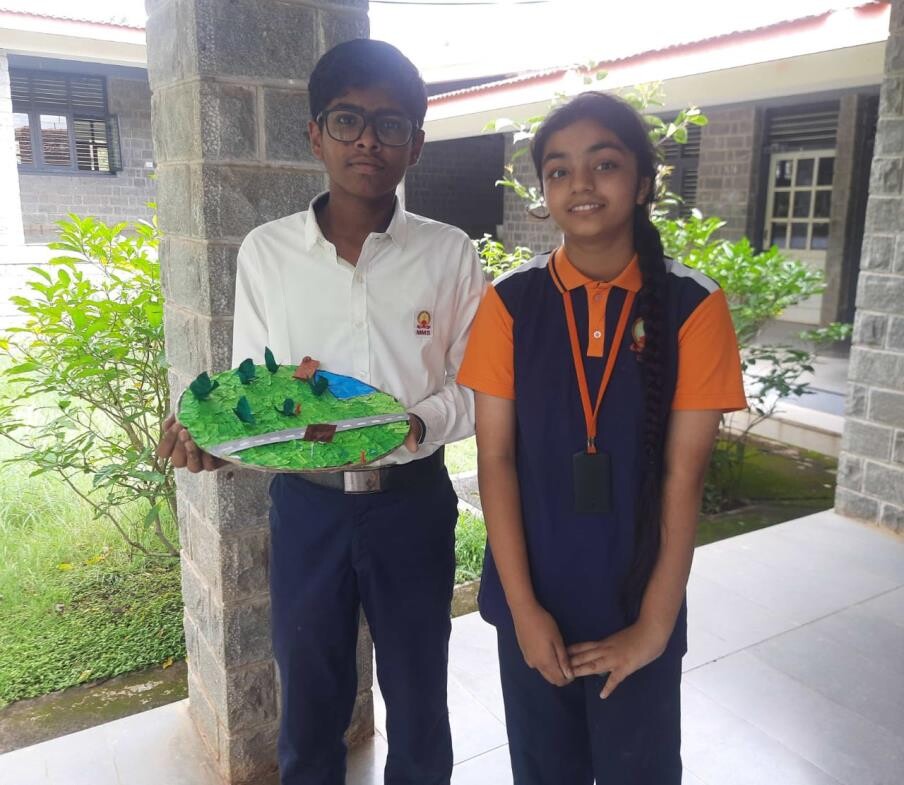 Lohith N and Vaishnavi J holding their circular garden prototype model
