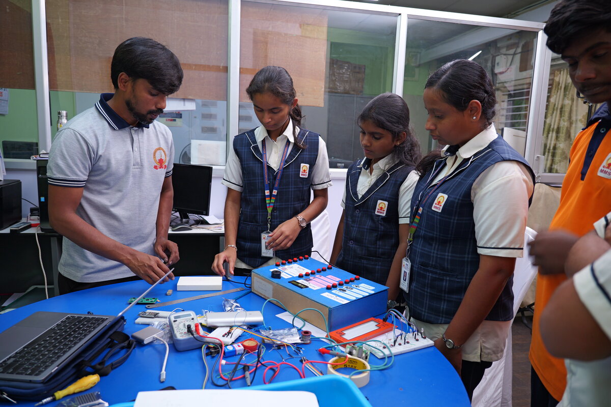 A teacher and students testing the SEVS panel, with buttons for Head Boy, Head Girl and Sports Secretary already wired in