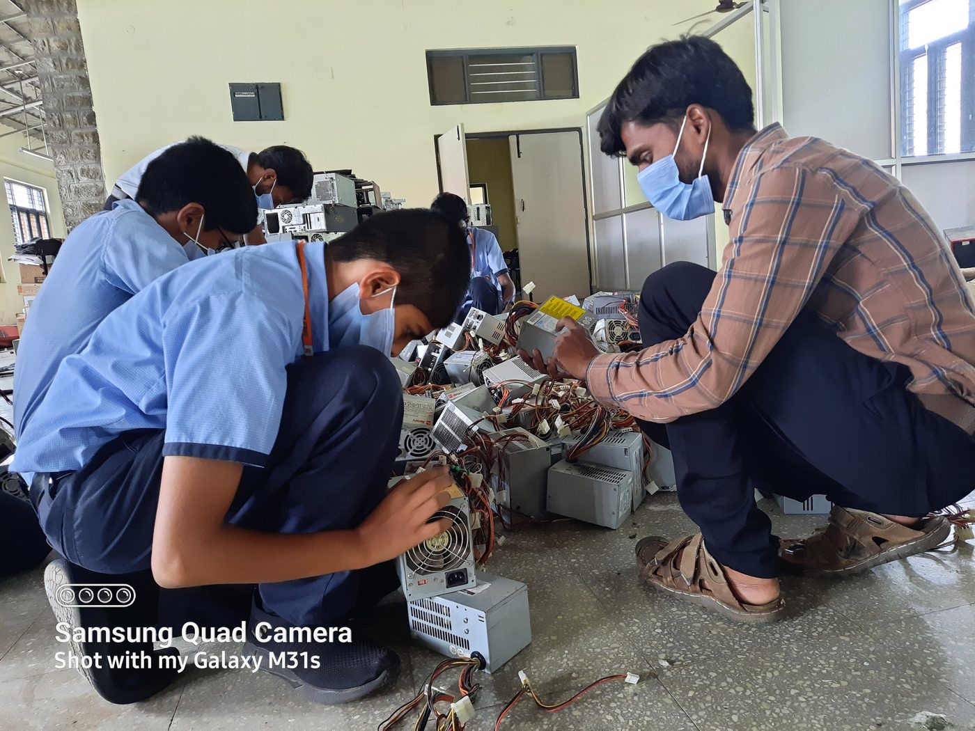 Close-up of students disassembling a power supply unit