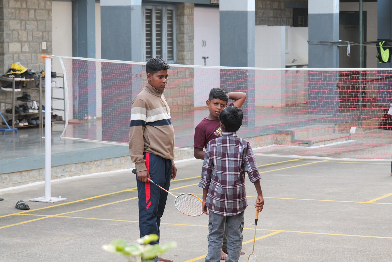 Boarders playing badminton in a hostel courtyard