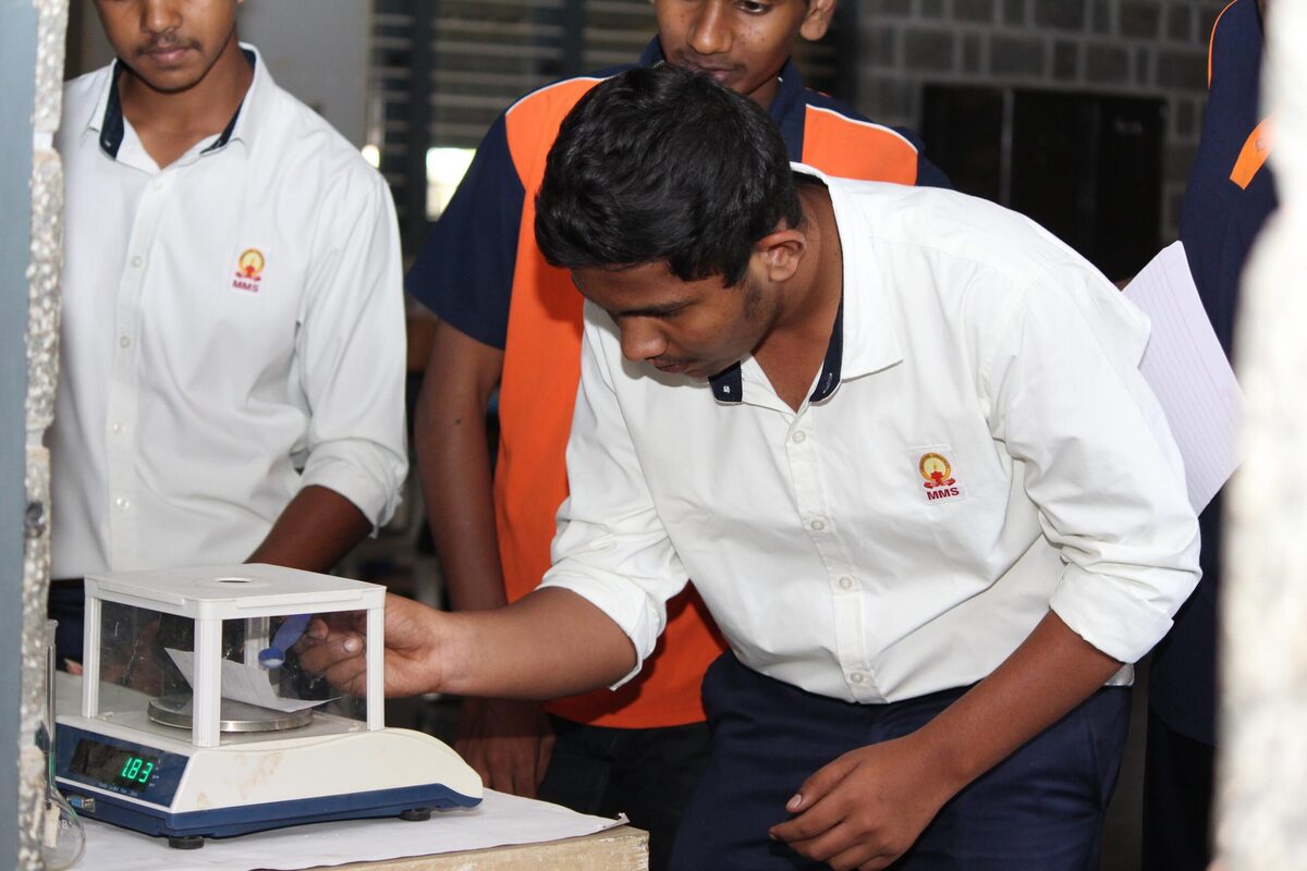 Students using a digital balance to weigh a chemical sample
