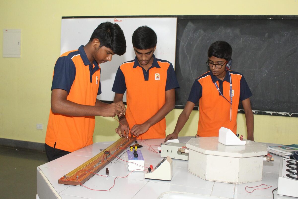 Students setting up a resistance experiment on the physics lab workbench