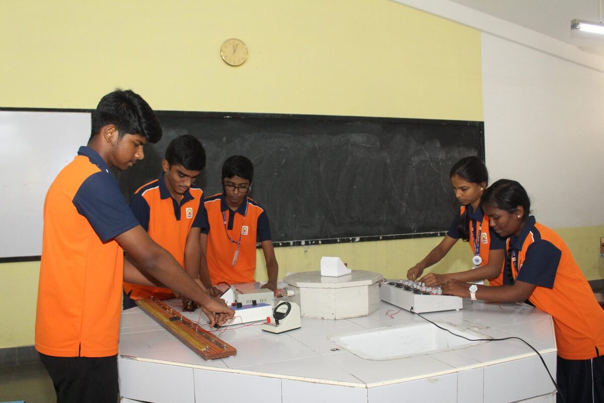 Students working with a meter bridge apparatus in the physics lab