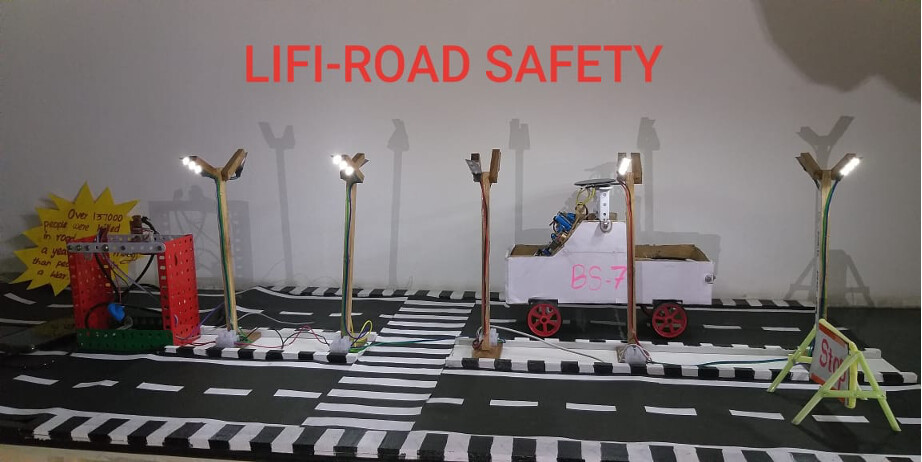LiFi Road Safety demo: LED highway posts, an in-car receiver unit, and a stop sign on a model road