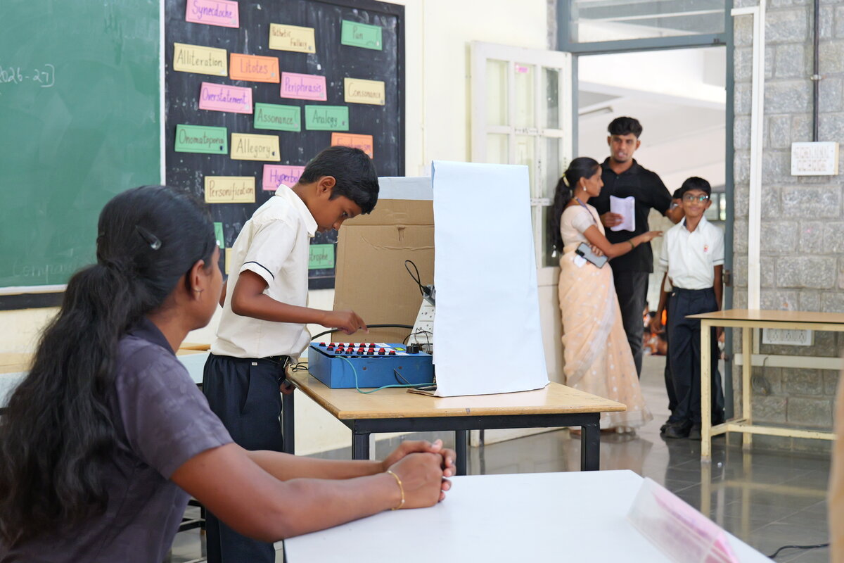A student casting a vote on the SEVS machine behind the polling booth screen