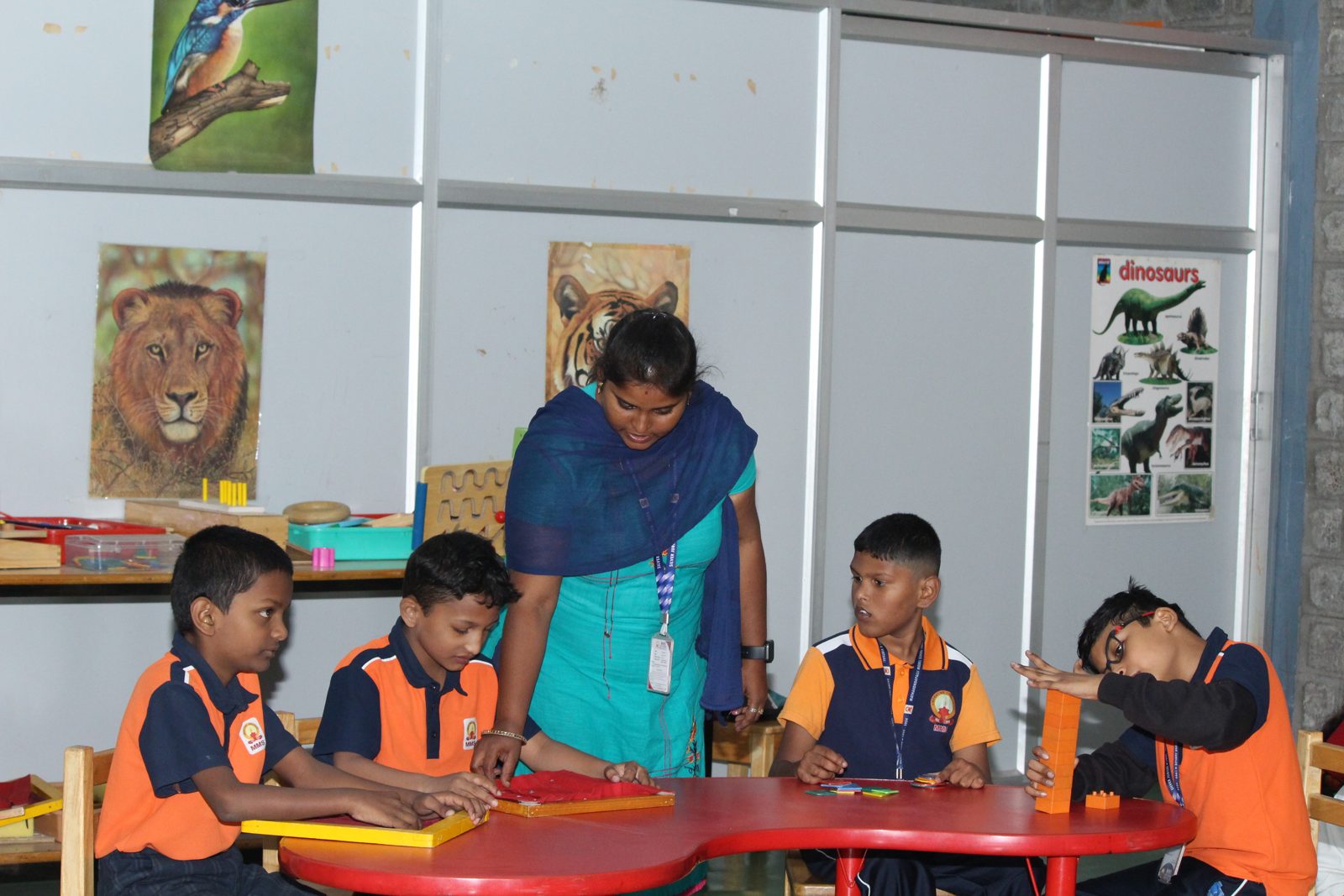 A special educator supporting a row of students at their activity boards