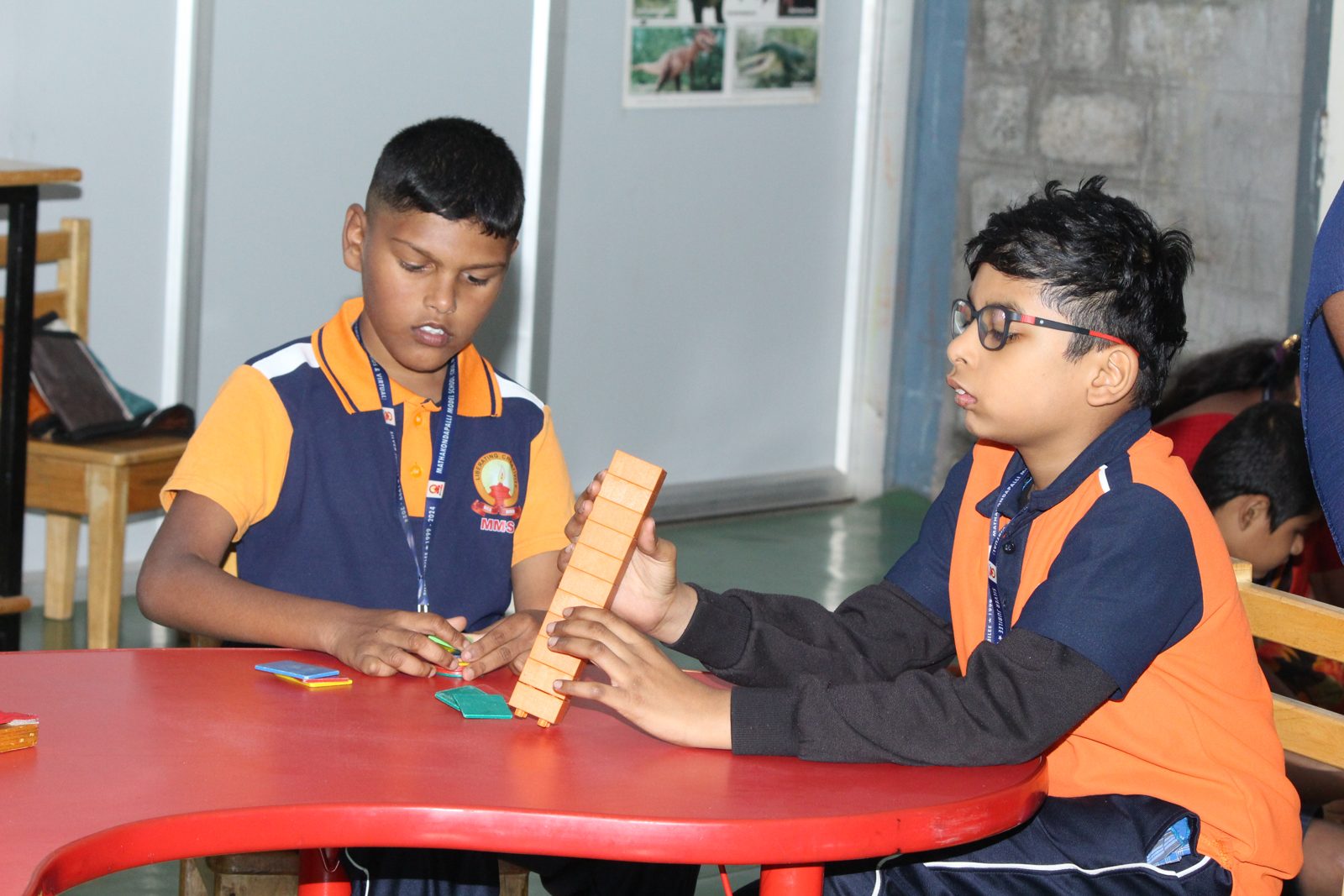 Two students building with wooden blocks at a table