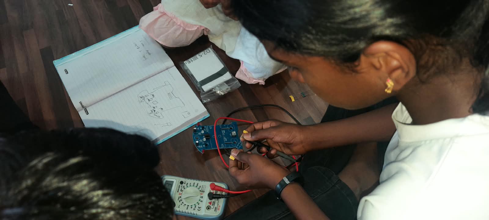 Student measuring a component's value with a multimeter